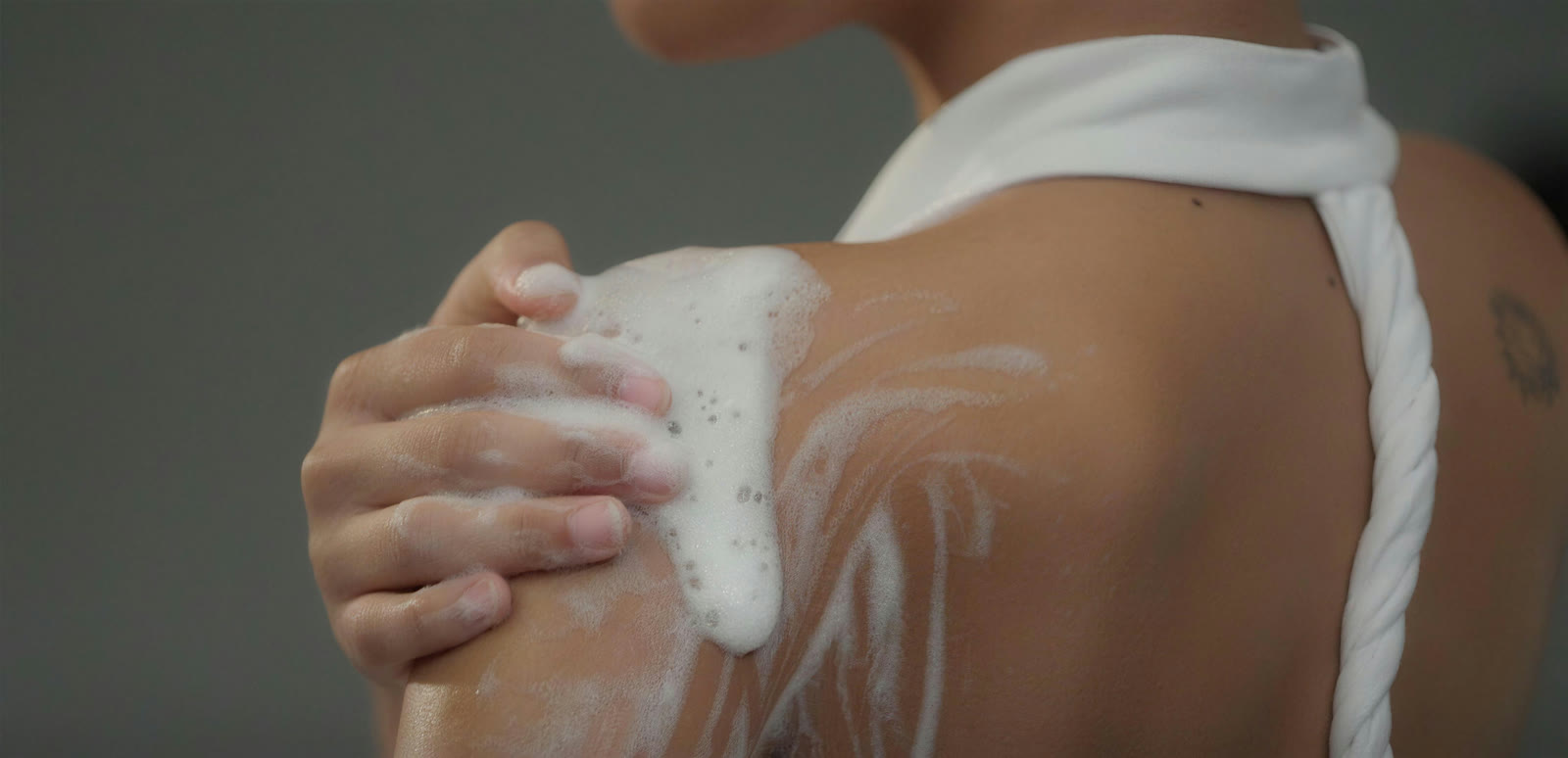 Body Lotion wird sanft auf die Schulter aufgetragen